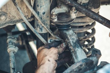 Bir arabanın fren diskini tamir eden tamircinin elleri