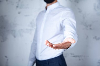 Genç adam avucunu soyut arkaplanda boş bırakıyor.