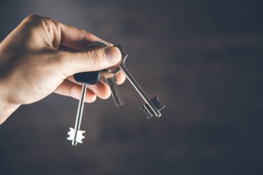 Adam arka planda anahtarı tutuyor.