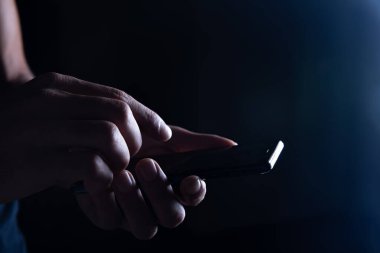 Karanlık arka planda erkek cep telefonu.