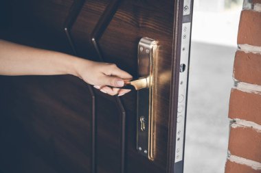 Genç bir kadın evin kapısını açıyor.