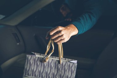 Hırsızın biri arabada çanta çalıyor.
