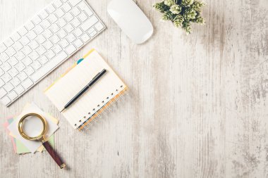 Masasında büyüteç ve bilgisayar olan not defteri