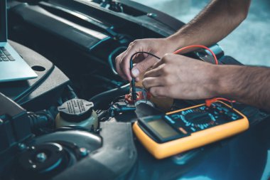 İşçi el bilgisayarı ve arabada test cihazı.