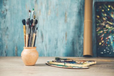 Soyut arkaplanda masanın üzerindeki boya fırçaları