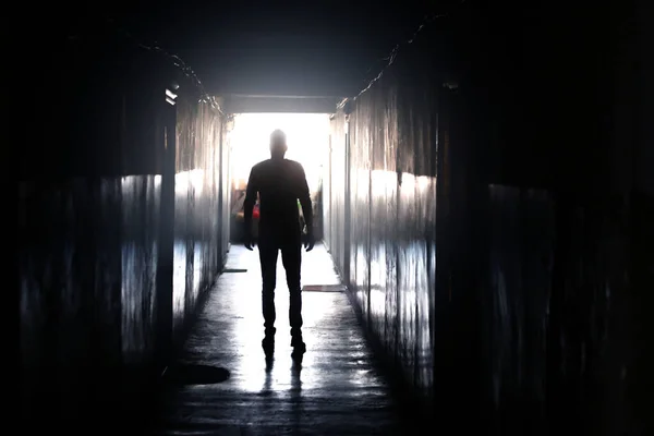 Man walking down a dark corridor