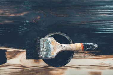 Ahşap arka planda siyah boya ve fırça