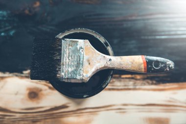 Ahşap arka planda siyah boya ve fırça