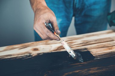 Erkek eli siyah boya ve ahşap fırça