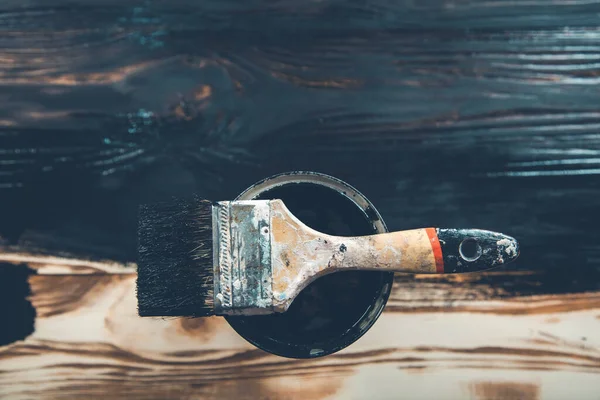 Ahşap arka planda siyah boya ve fırça