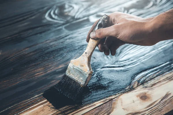 Erkek eli siyah boya ve ahşap fırça