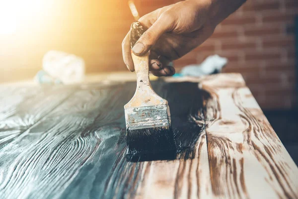 Erkek eli siyah boya ve ahşap fırça