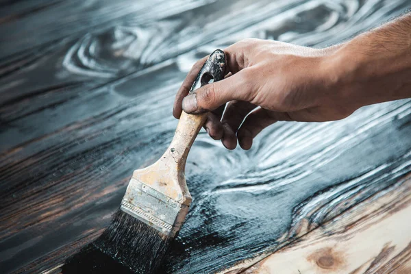 Erkek eli siyah boya ve ahşap fırça