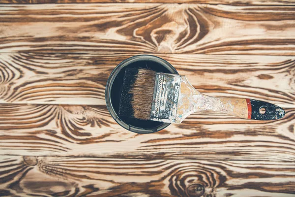 Ahşap arka planda siyah boya ve fırça