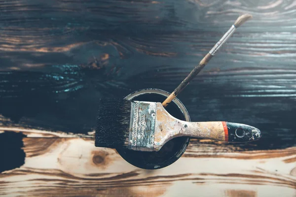 Ahşap arka planda siyah boya ve fırça