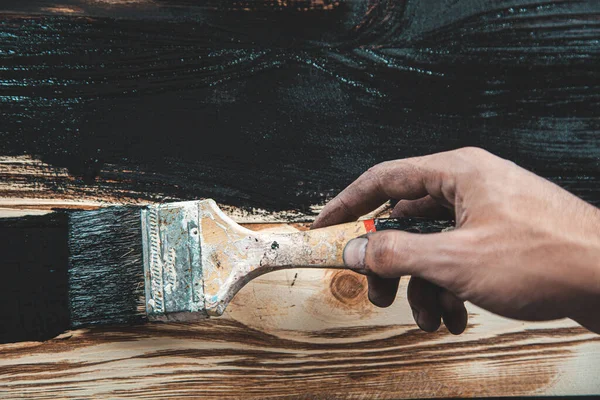 Erkek eli siyah boya ve ahşap fırça