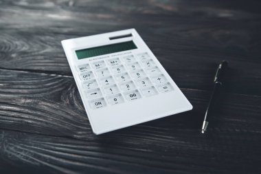 Siyah arkaplanda kalem olan hesap makinesi