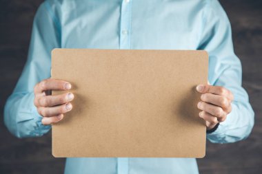 Kahverengi kağıt tutan adam.