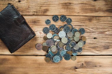 Tahta masanın üzerinde bozuk paralar olan hesap makinesi.