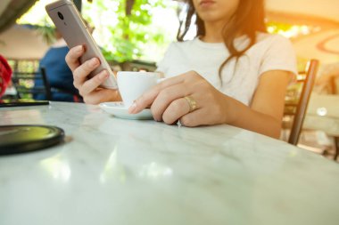 Kafede kahveli kadın cep telefonu.