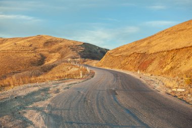 Mavi gökyüzünün altındaki dağ yolu