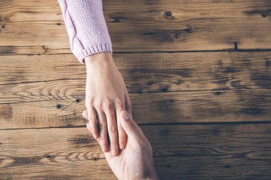 Kadın ve erkek elleri masanın üstünde.