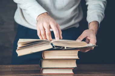 man reading book on the wooden desk