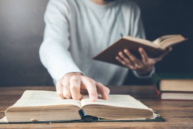 man reading book on the wooden desk
