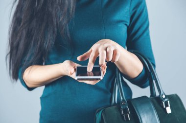 woman hand phone with bag on gray background