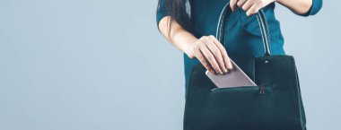 woman hand phone with bag on gray background