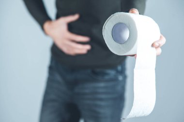 man hand in ache belly with toilet paper