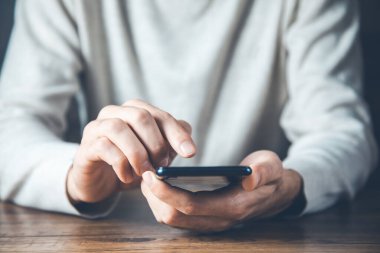 young man hand phone on desk