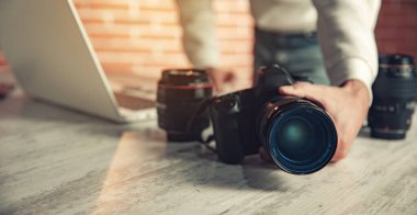 fotoğrafçının el kamerası masada çalışıyor.