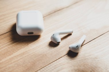 Masanın üzerinde beyaz kablosuz kulaklık var.