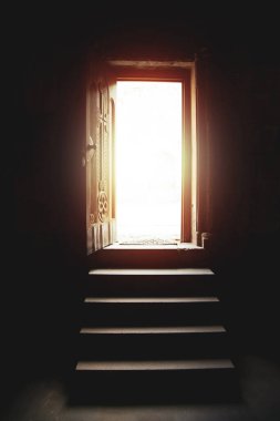Kilisenin açık kapısından içeri ışık giriyor.