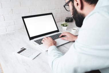 Masada bilgisayar ve hesap makinesinde çalışan bir adam