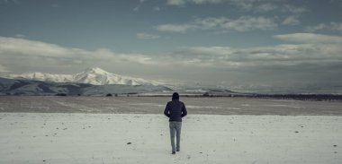 Dağlarda karlı arazide bir adam.