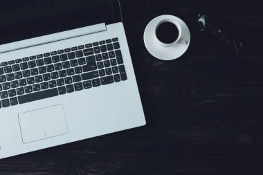 Masanın üzerinde defter olan bir fincan kahve.