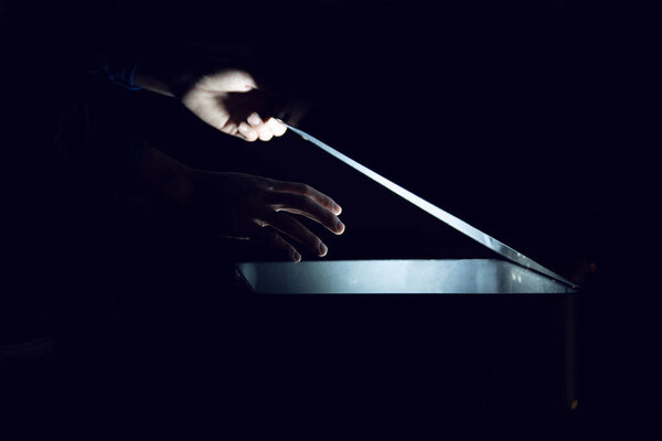 человек со светлым ящиком на темном фоне