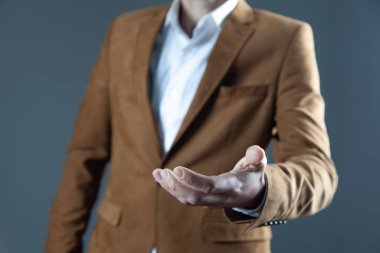 İş adamı gri arka planda avuç içi boş