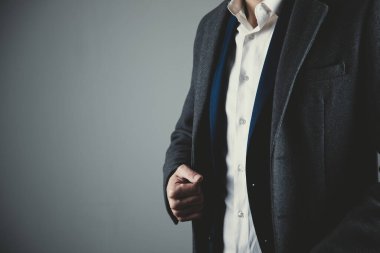 Koyu arkaplanda insan eli kıyafet düğmesi