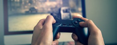 Video oyunu oynayan adam. Eller konsol kontrolörüName