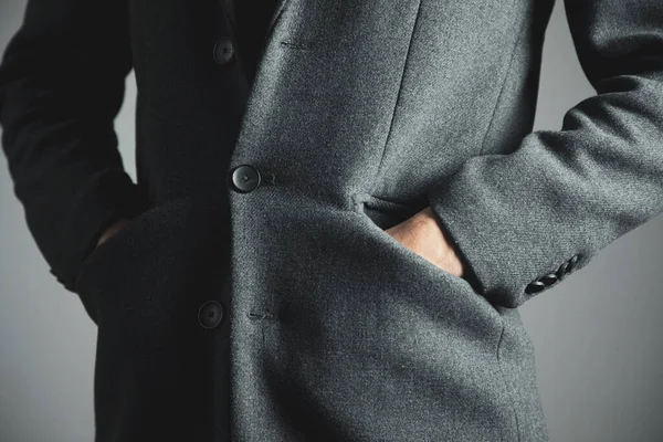 Άνθρωπος Χέρι Στην Τσέπη Κοστούμι Γκρι Φόντο — Φωτογραφία Αρχείου