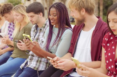 Akıllı cep telefonlarını izleyen bir grup arkadaş. Gençlerin yeni teknoloji eğilimlerine olan bağımlılığı. Gençlik, teknoloji, sosyal ve arkadaşlık kavramı.