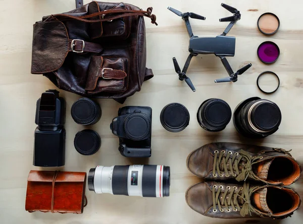 Overhead of photography accessories arranged neatly on a wooden table. Technology, photography accessories, OCD