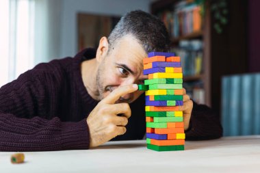Renkli bloklarla oynayan çekici, olgun bir adam. Kavramsal iş, yaşam tarzı