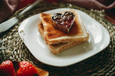 Kalp şeklinde reçelli tost. Kavramsal Sevgililer Günü, aşk, romantizm