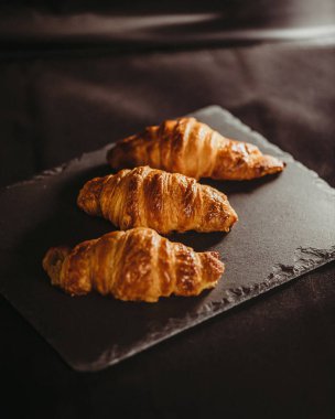 Siyah taş tabakta kruvasan.
