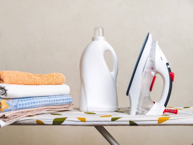 Demir modelin yanında beyaz deterjan şişesi.