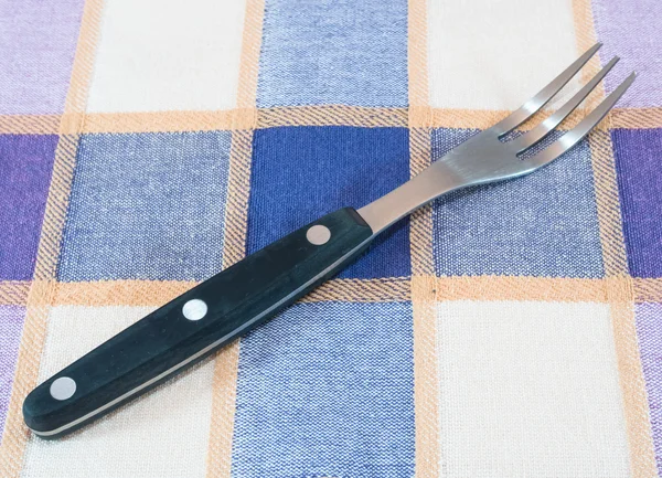 Artigos de cozinha: garfo na toalha de mesa — Fotografia de Stock